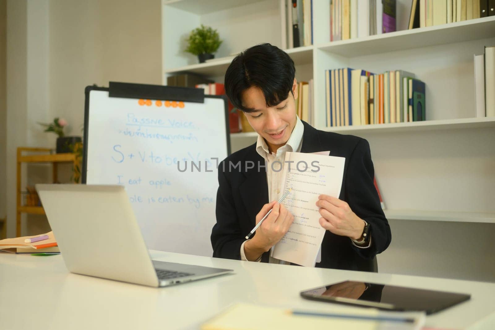 Smiling tutor explaining a worksheet to student during an online learning session.