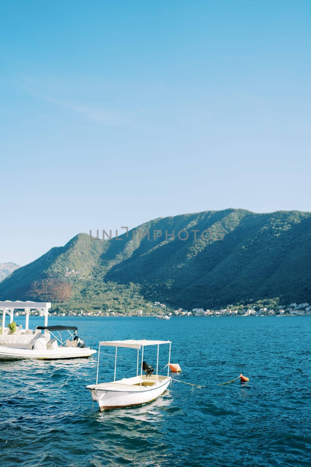 Excursion boats moored in the sea opposite the mountains. High quality photo