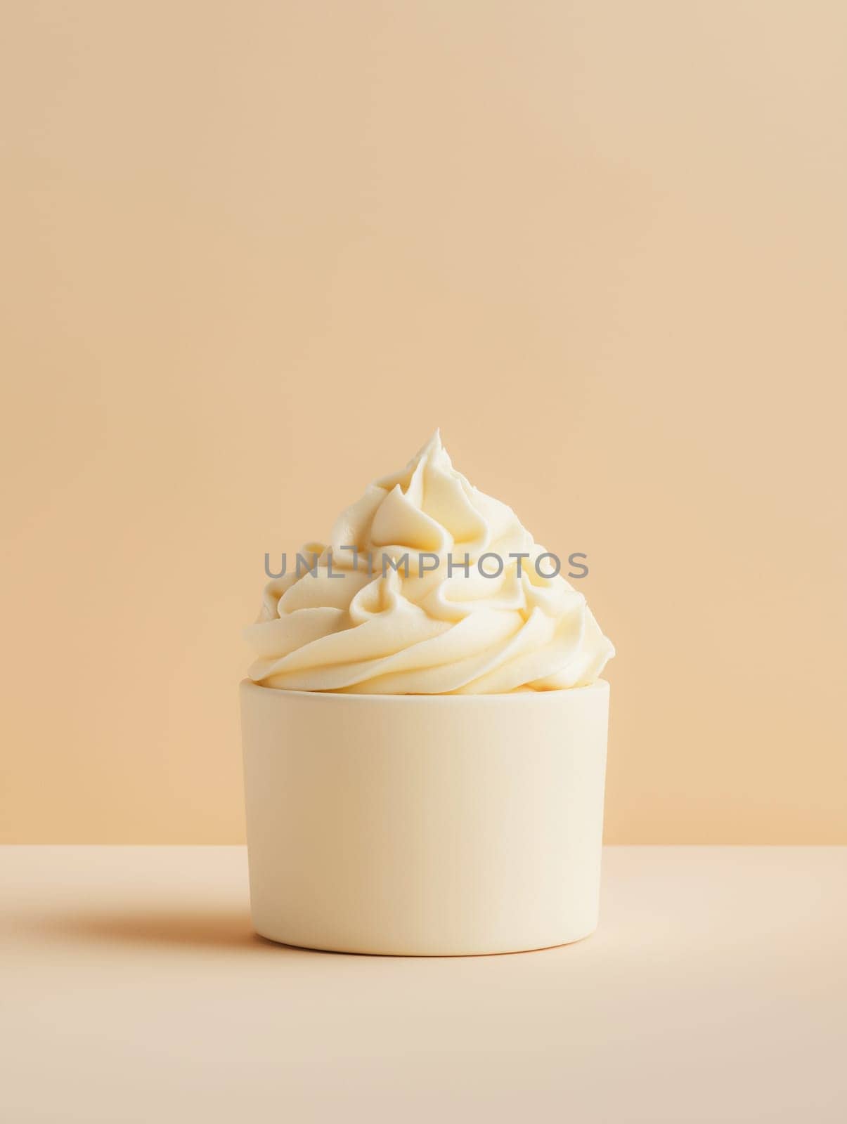 Creamy whipped topping sits atop a light beige cup, showcasing a simple dessert display. No one is present.