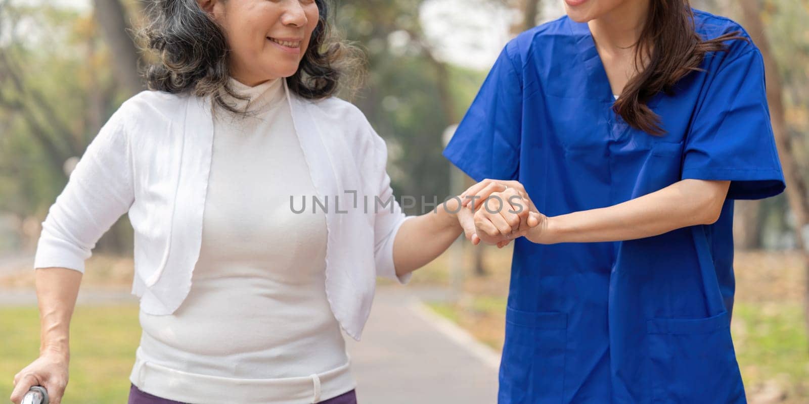 Nurse and senior in elderly care, support or walking with stick at park. Medical caregiver or therapist help patient or person with a disability in retirement or physiotherapy.