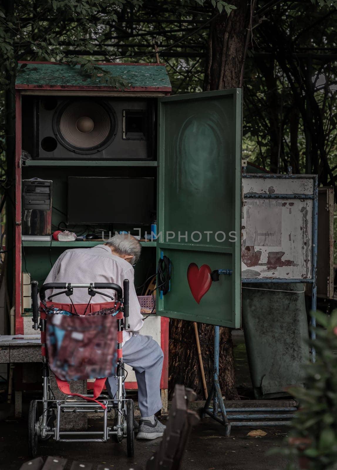 Bangkok, Thailand - 22 Sep, 2023 - The old grey-haired man is controlling and playing the musical instrument in the park for entertaining people who come to relax and workout. Selective focus.