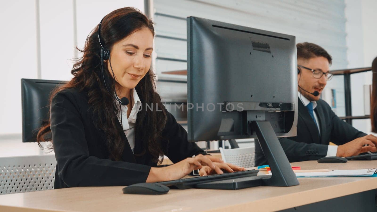 Business people wearing headset working in office to support remote customer or colleague. Call center, telemarketing, customer support agent provide service on telephone video conference call. Jivy