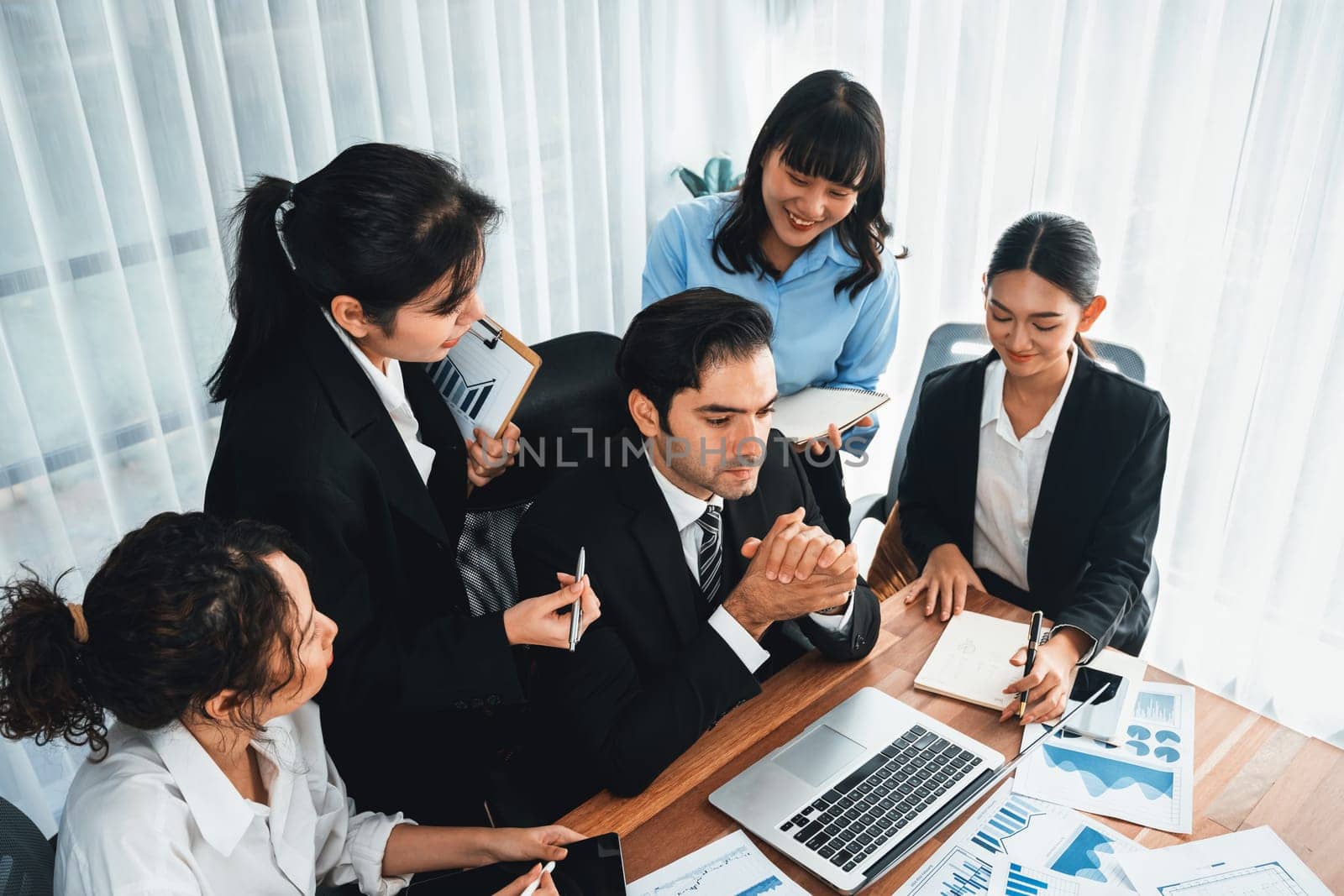 Diverse group of business analyst team analyzing financial data report paper on office table. Chart and graph dashboard by business intelligence analysis for strategic marketing planning Meticulous