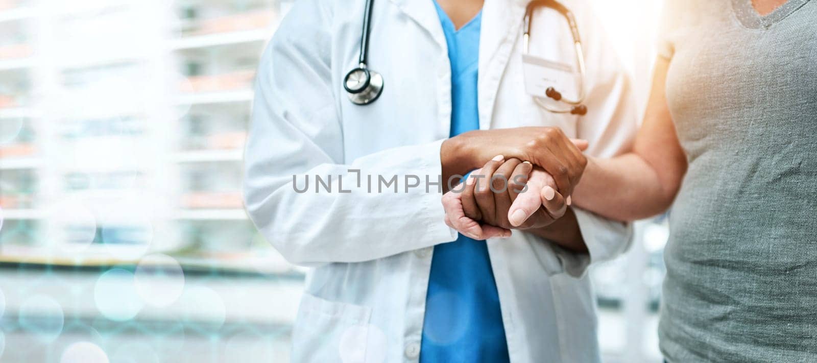 Closeup, doctor and patient with support, holding hands and teamwork with lens flare, banner and healthcare. People, medical professional and woman with medicare, hospital and compassion with empathy.