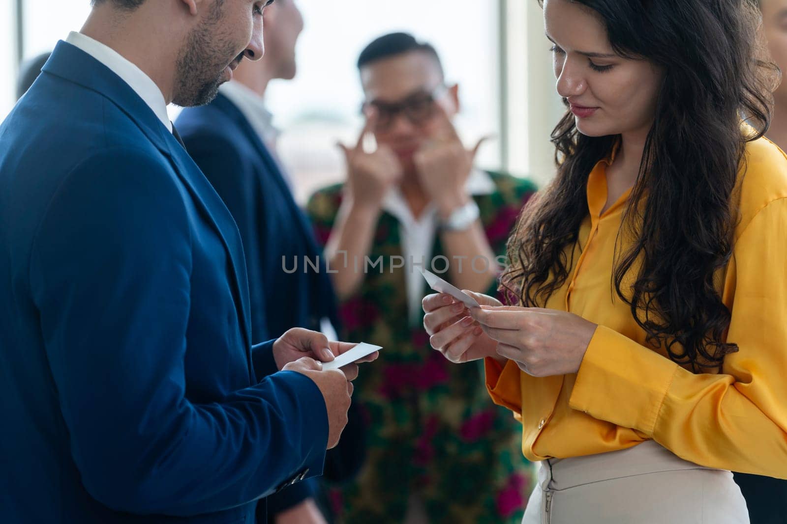 Successful businesswoman holding the name card during talking to manager about their cooperation. Cropped image of exchanging name card between businessman and businesswoman. Side view. Intellectual.