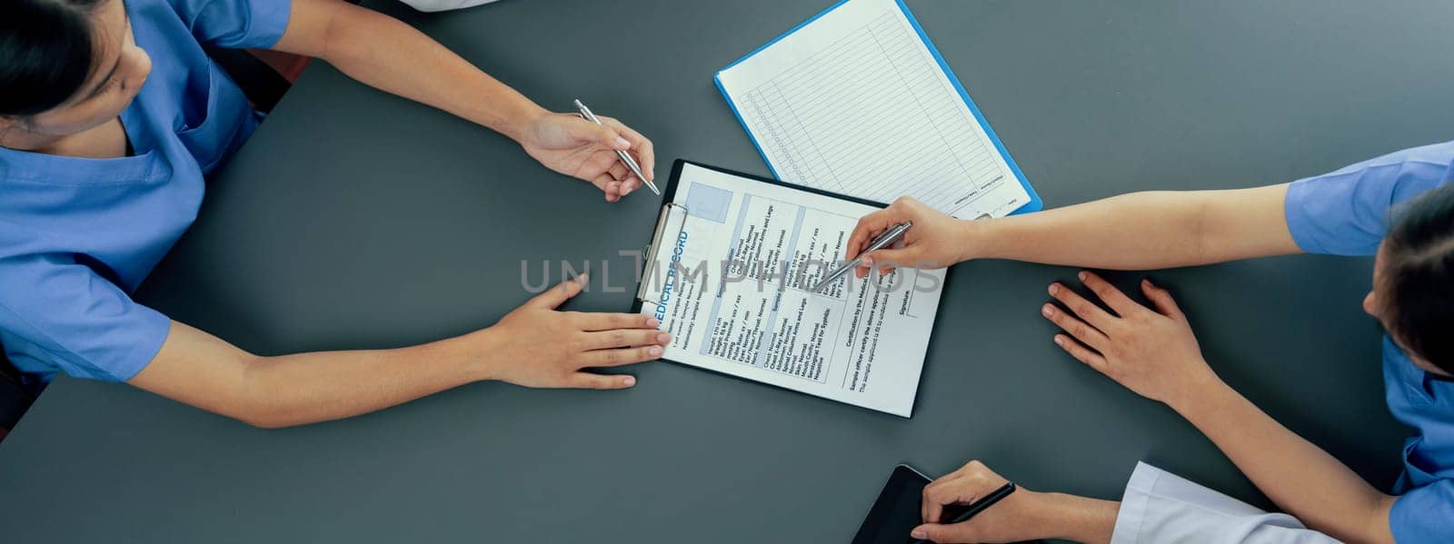 Doctor and nurse in medical meeting discussing strategic medical treatment plan together with report and laptop. Medical school workshop training concept in top view panoramic banner. Neoteric