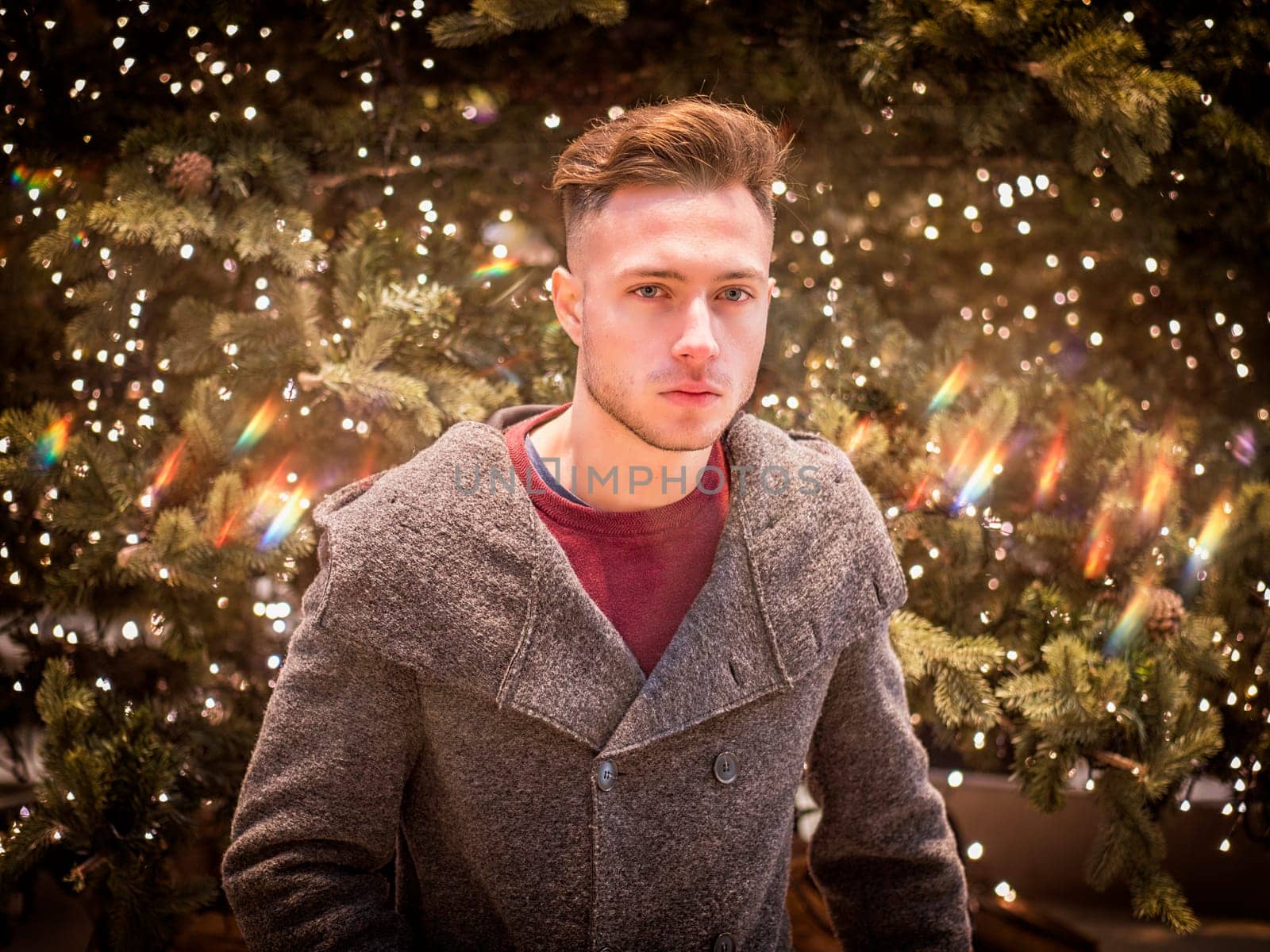 A man standing in front of a christmas tree
