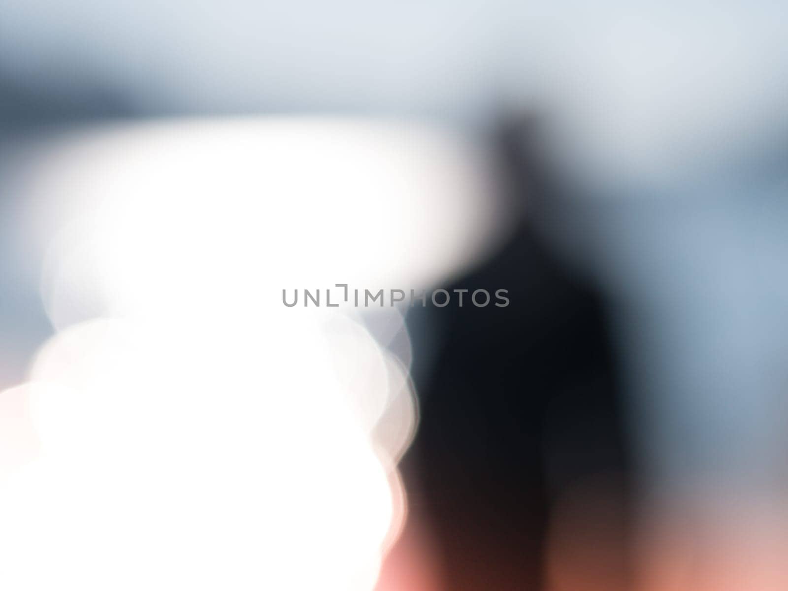 A blurry photo of a person in a suit. Photo of an unrecognizable person a black clothes with a blurred background