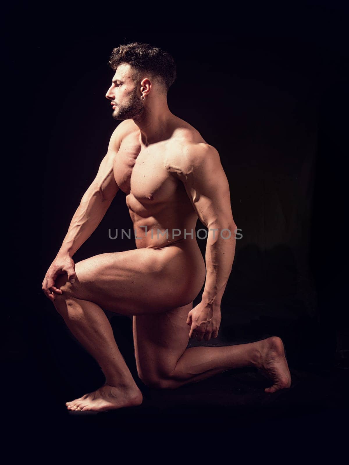 Photo of a shirtless man kneeling in darkness by artofphoto