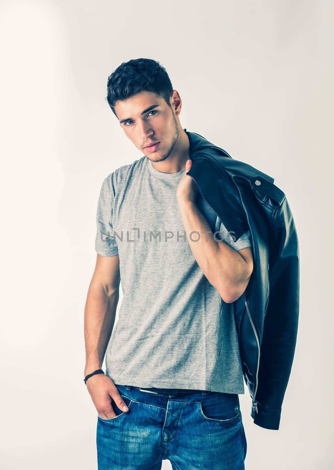 Photo of a man holding a jacket in a casual outfit by artofphoto