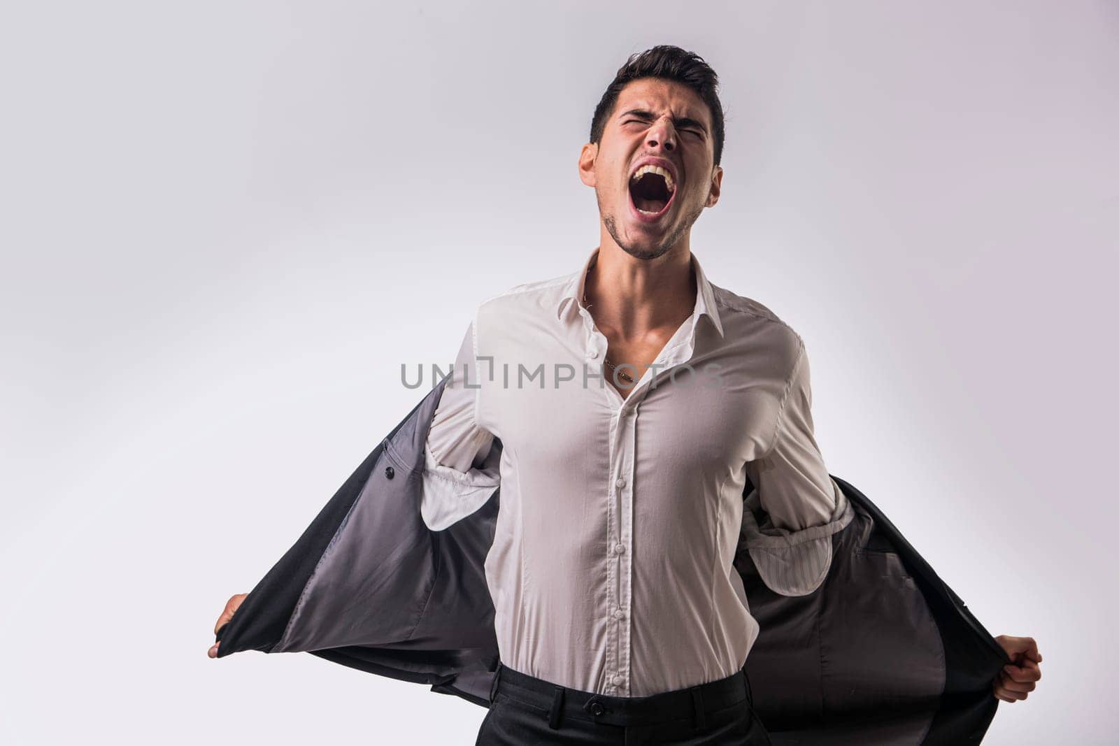 A man in a white shirt and black pants screaming with anger or frustration or desperation