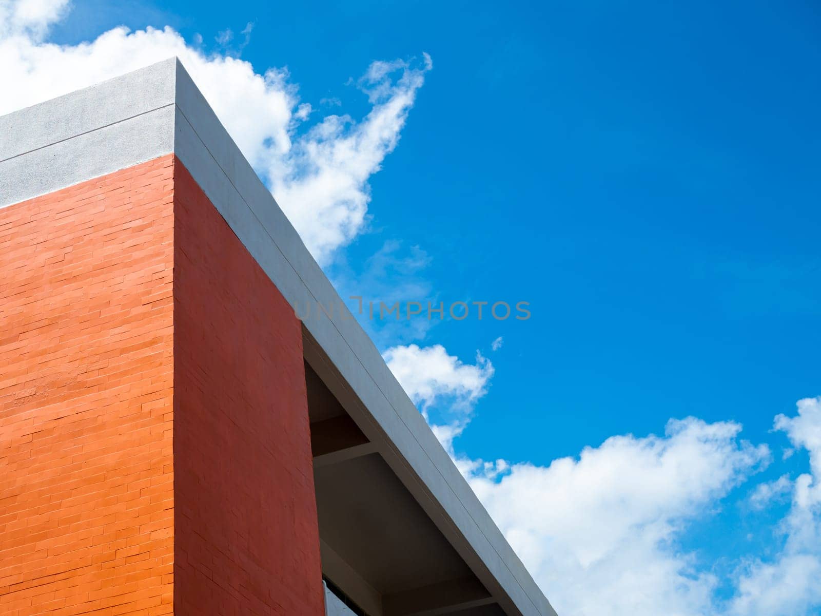 Orange building on a background of blue sky and white clouds.