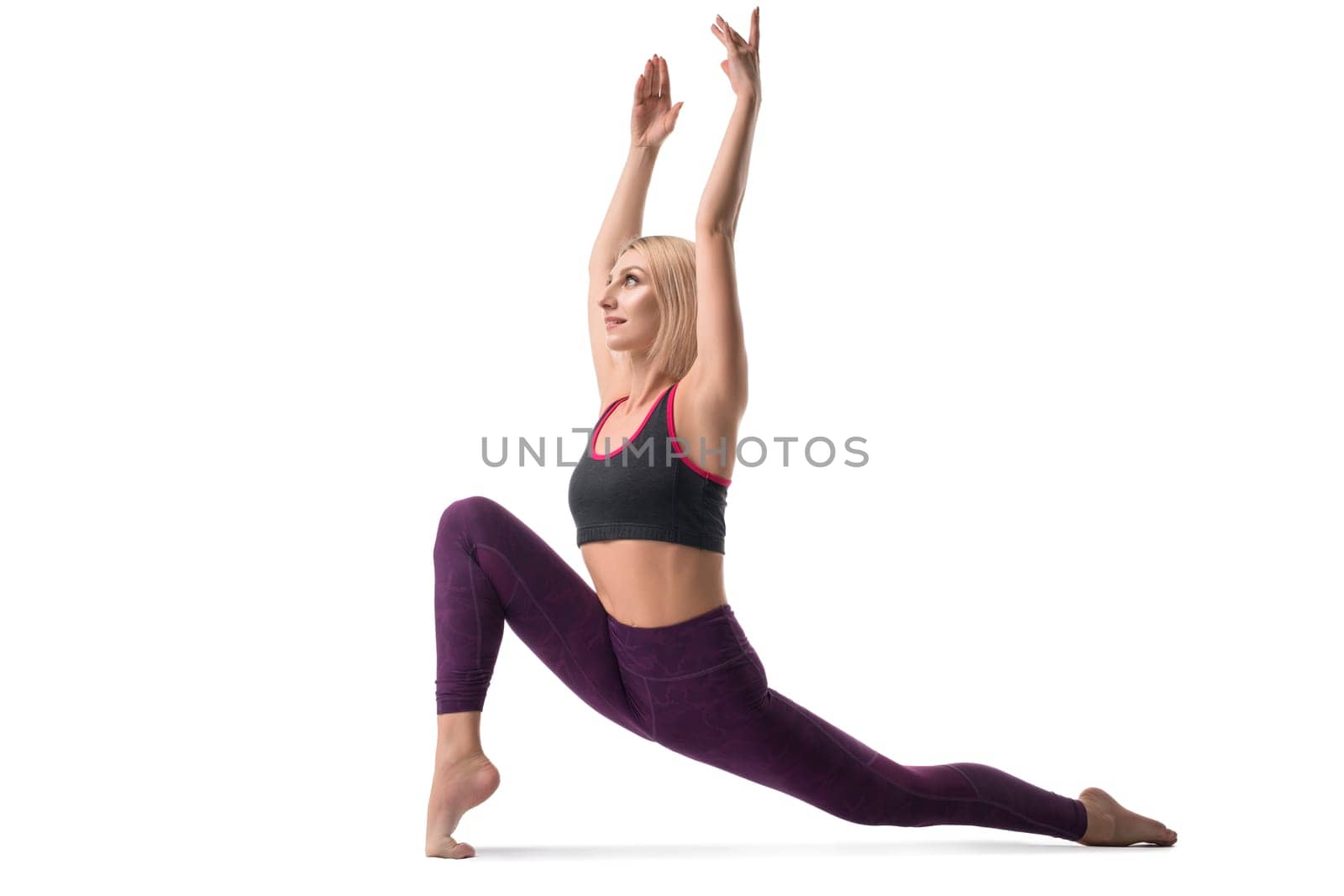 Slim blonde in sportswear on the floor practicing yoga isolated view
