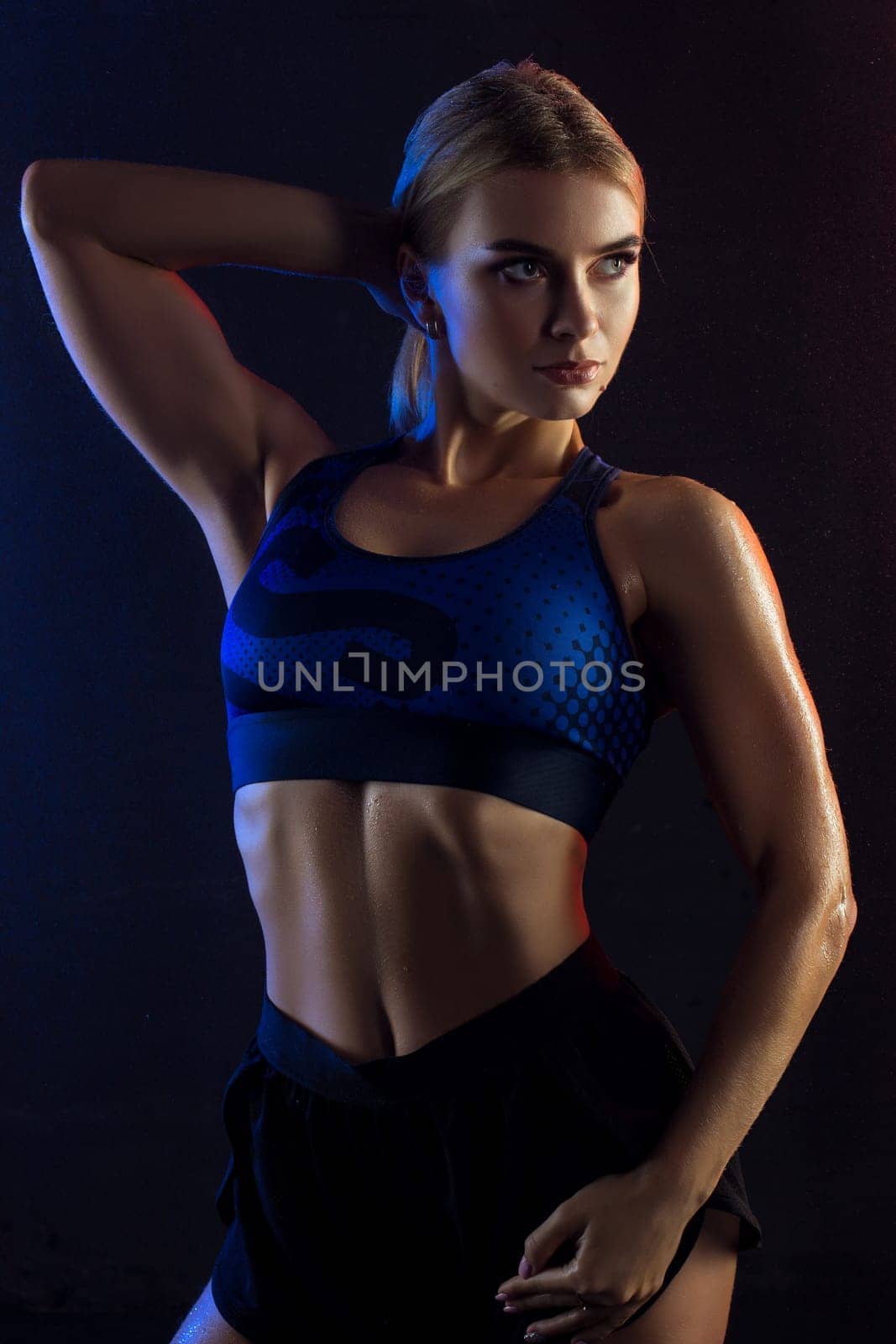 Athletic beautiful fitness model cropped shot against wall