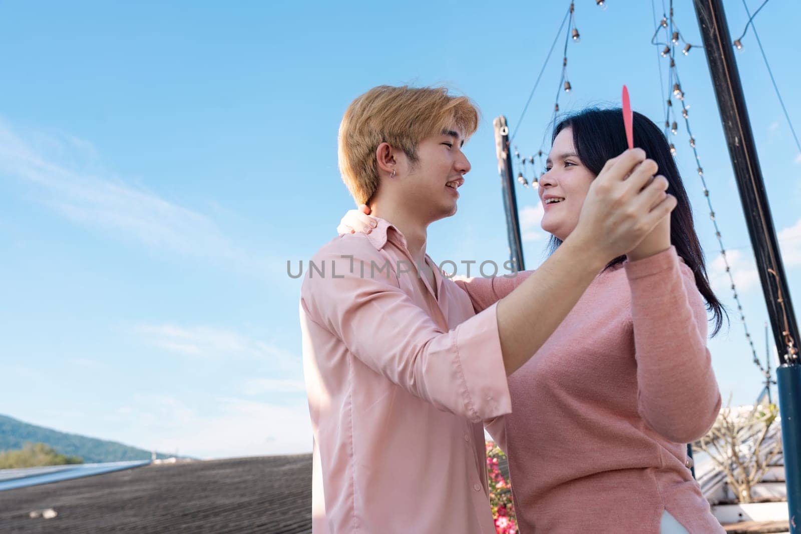 A couple joyfully celebrates their love under a clear sky creating lasting memories during Valentine's Day.