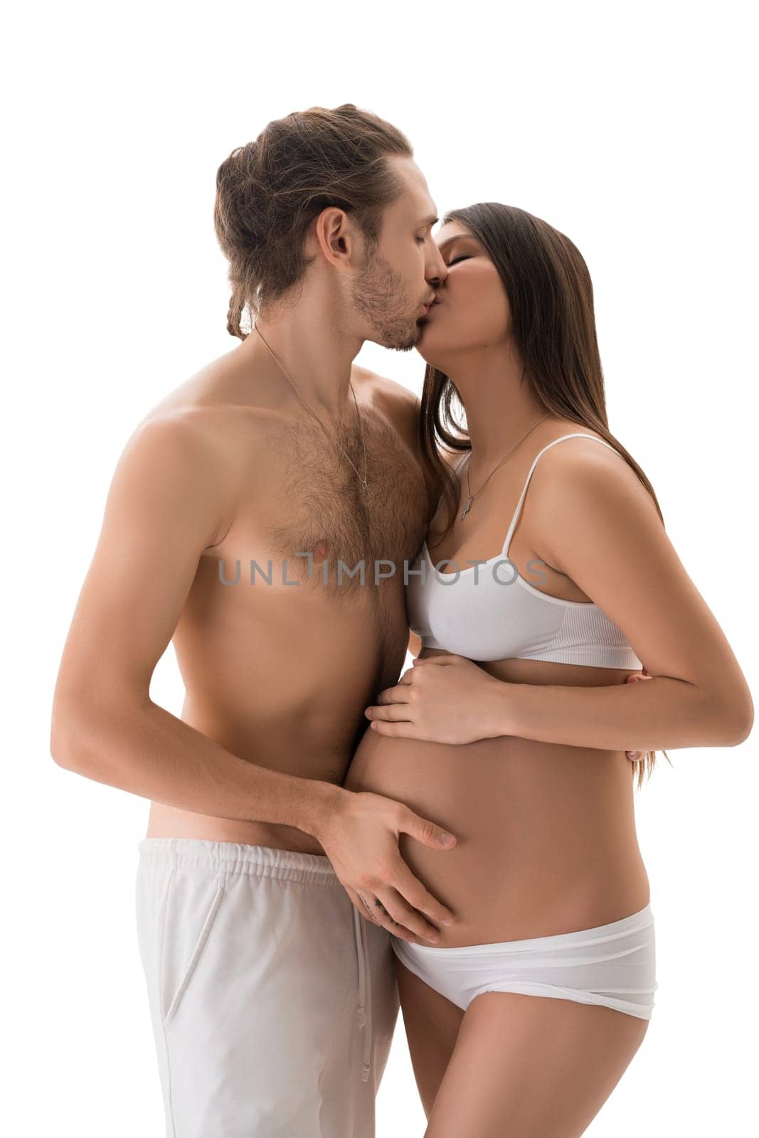 Handsome shirtless male with closed eyes kissing and touching beautiful pretty female against white background