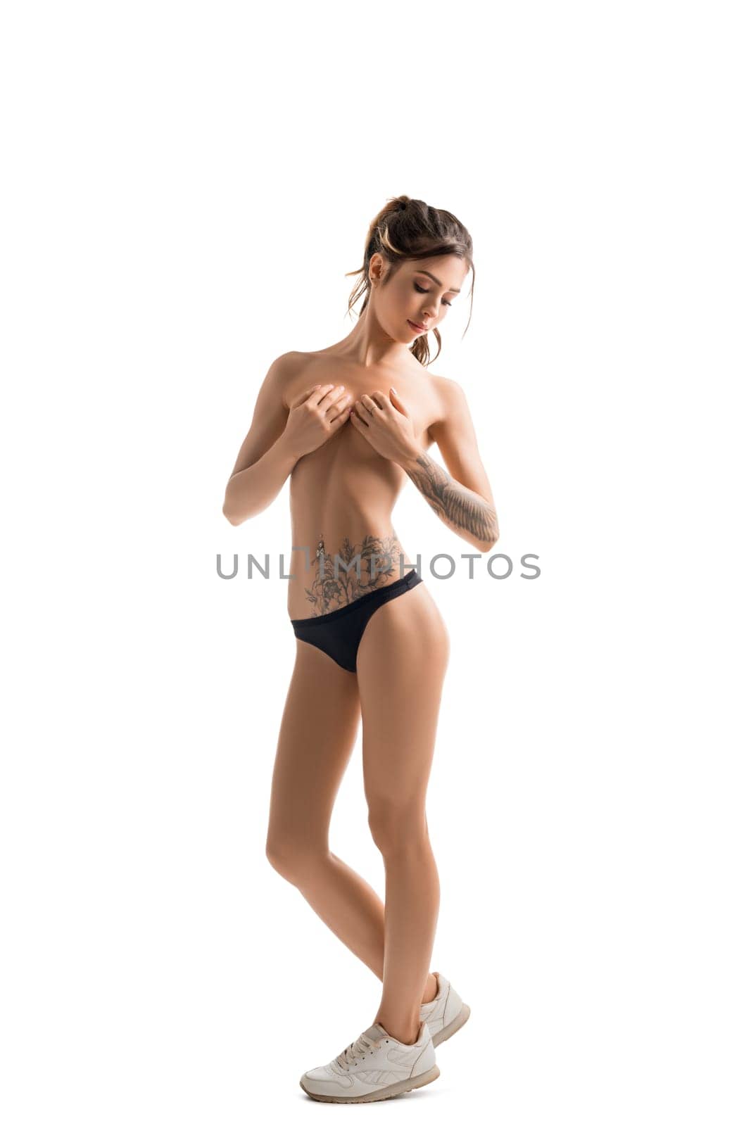 Slim tattooed girl topless isolated full-length shot