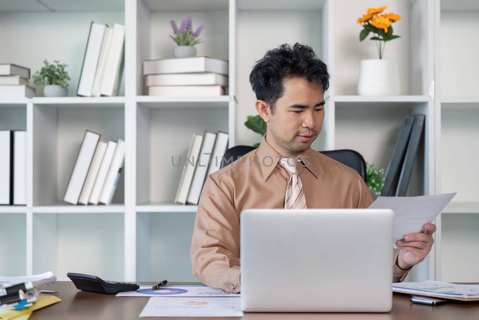A business professional analyzes important documents in a modern office highlighting productivity and focus in a serene setting.