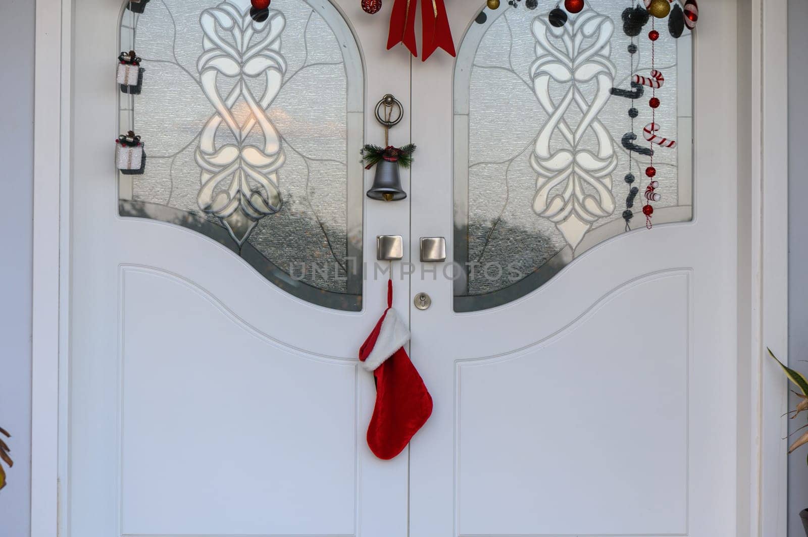 A bright and cheerful entrance showcases holiday decor, including a red stocking and sparkling ornaments on the door.