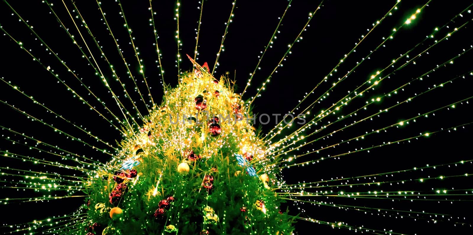 A beautifully decorated Christmas tree covered in colorful ornaments and bright lights radiates joy and warmth during the holiday season.