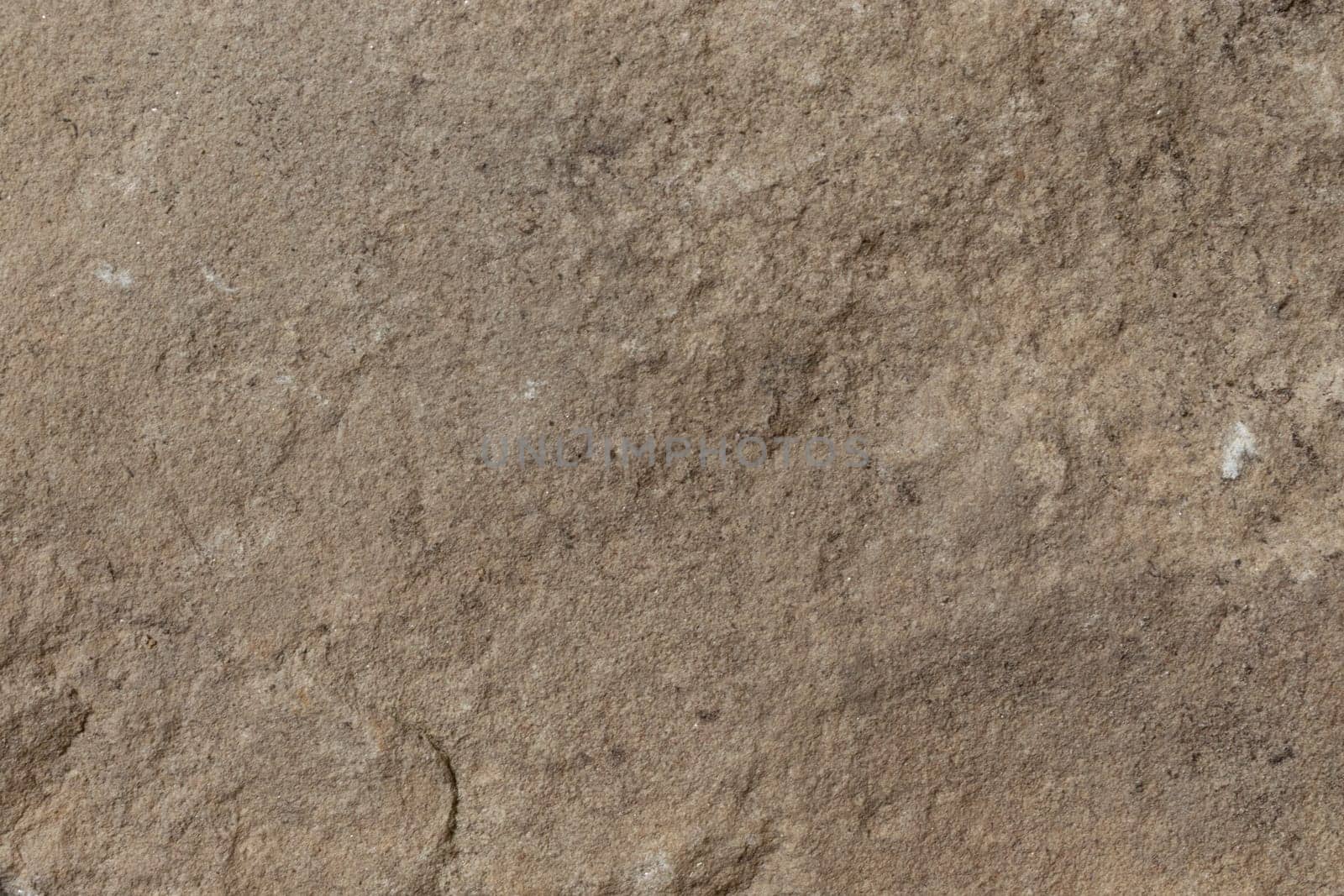 A rugged stone surface with earthy brown tones and natural textural details, ideal for use in organic or rustic-themed designs.