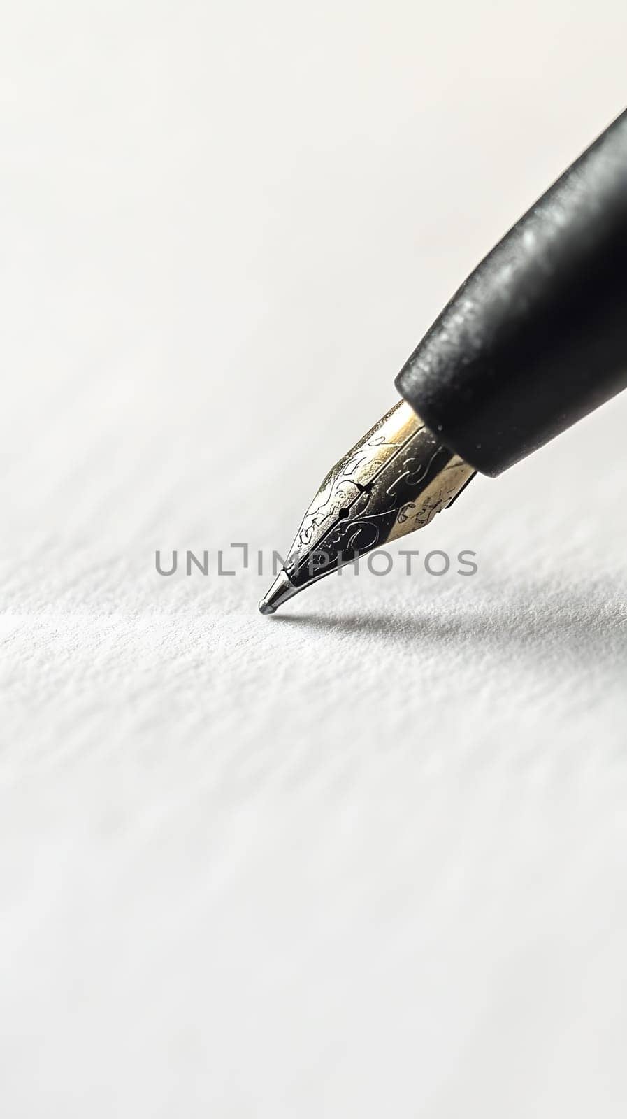 Close-up of a fountain pen poised above blank paper.