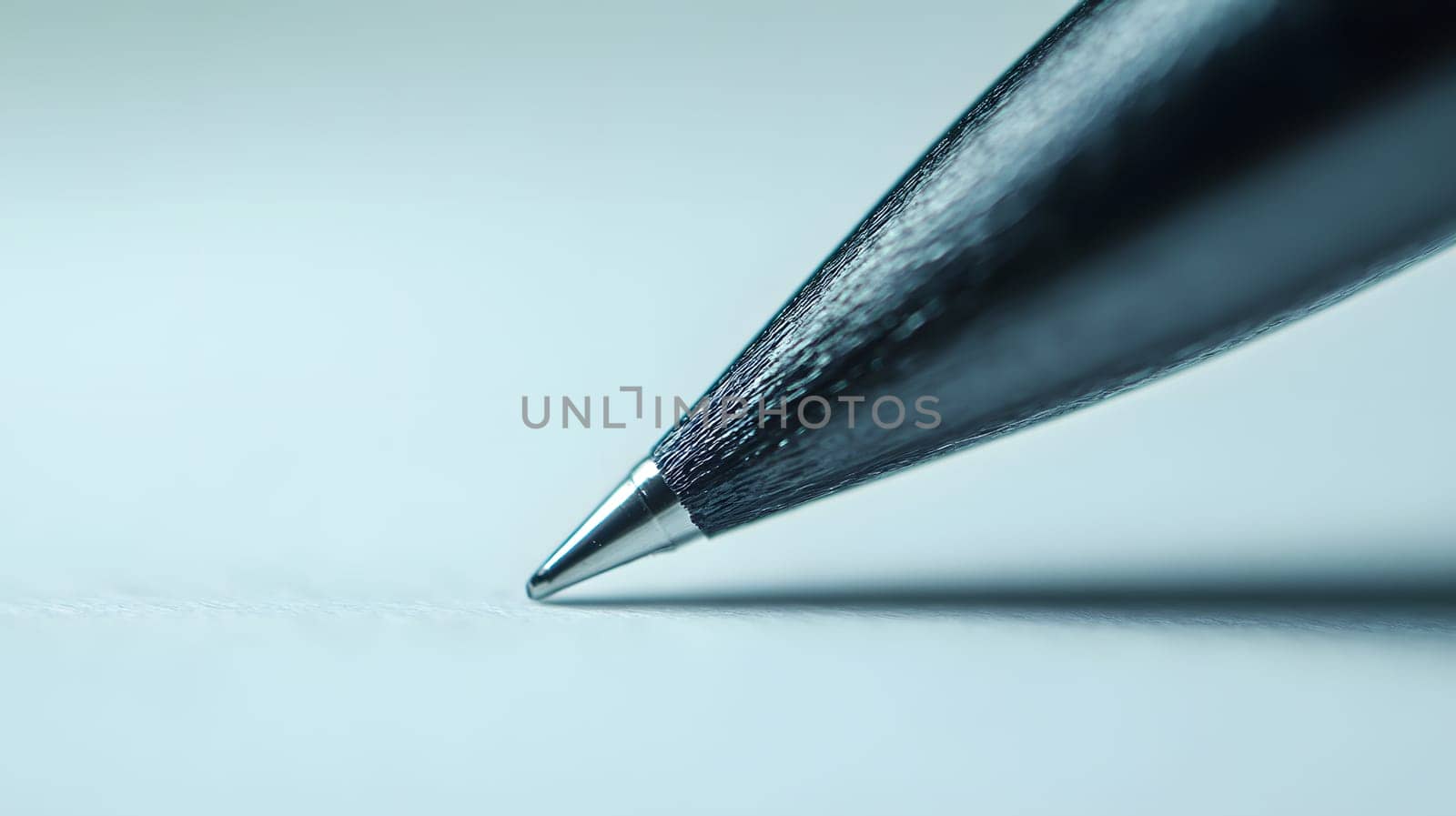 Close-up of a pen tip poised above a blank page.