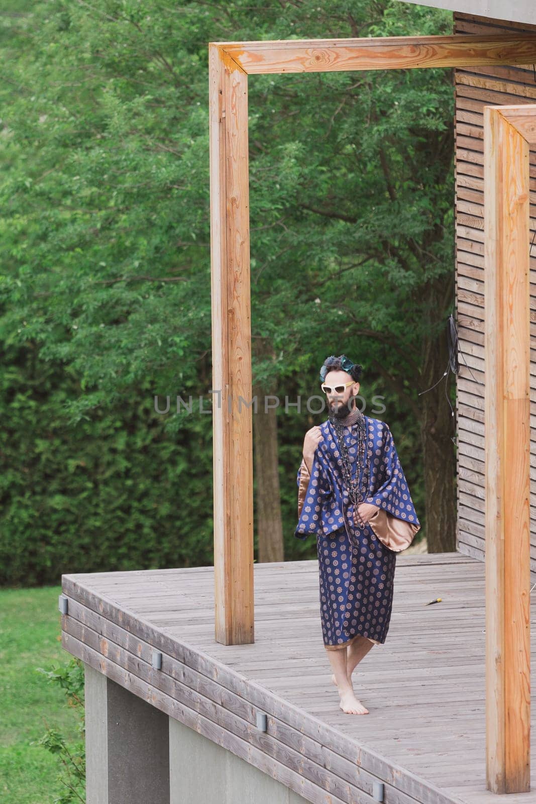 Young man wearing bathrobe night suit posing outdoor by sarymsakov