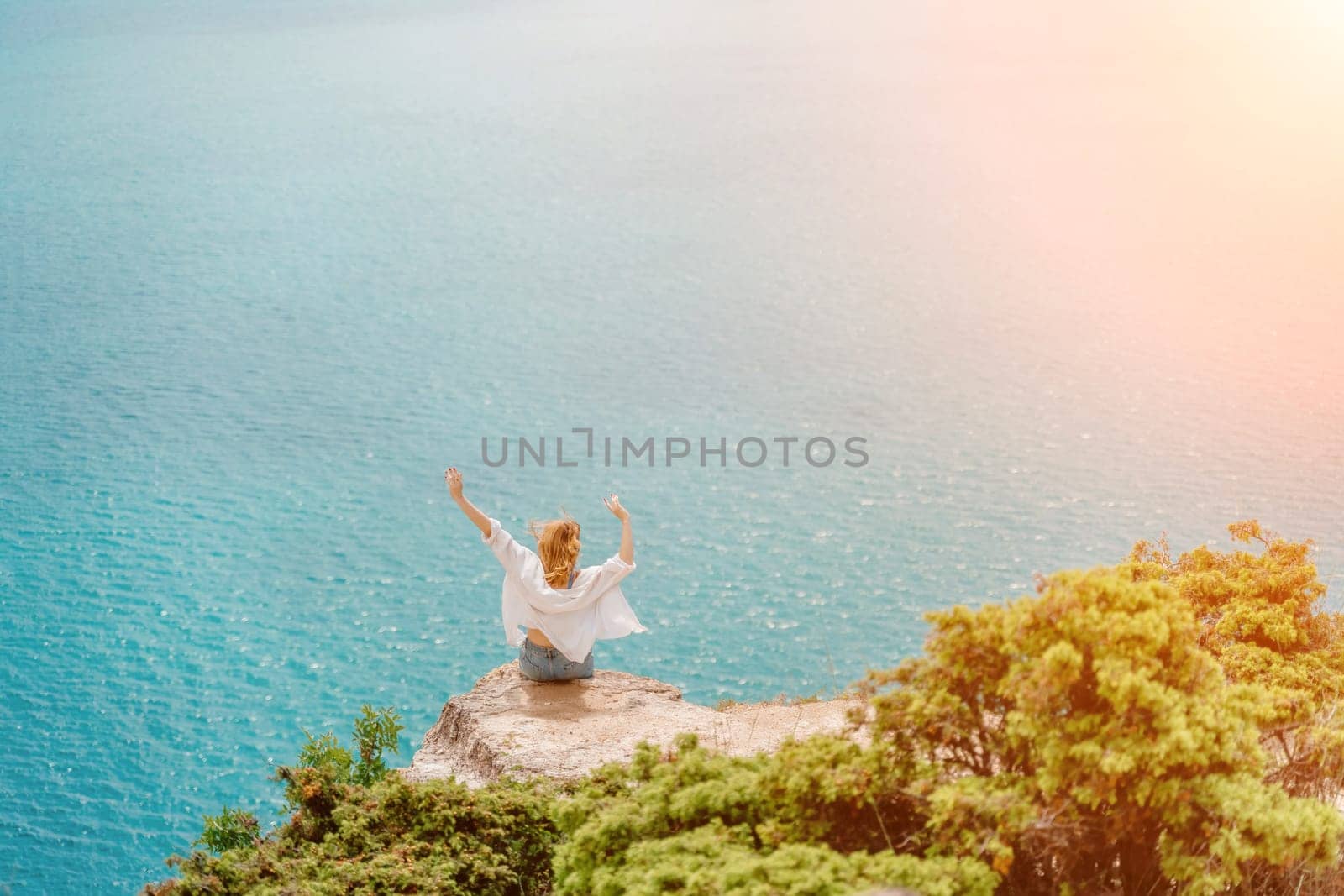 Woman travel summer sea. Portrait of a happy woman on a background of beautiful sea. Rear view of a woman in a white shirt. Freedom and happiness.