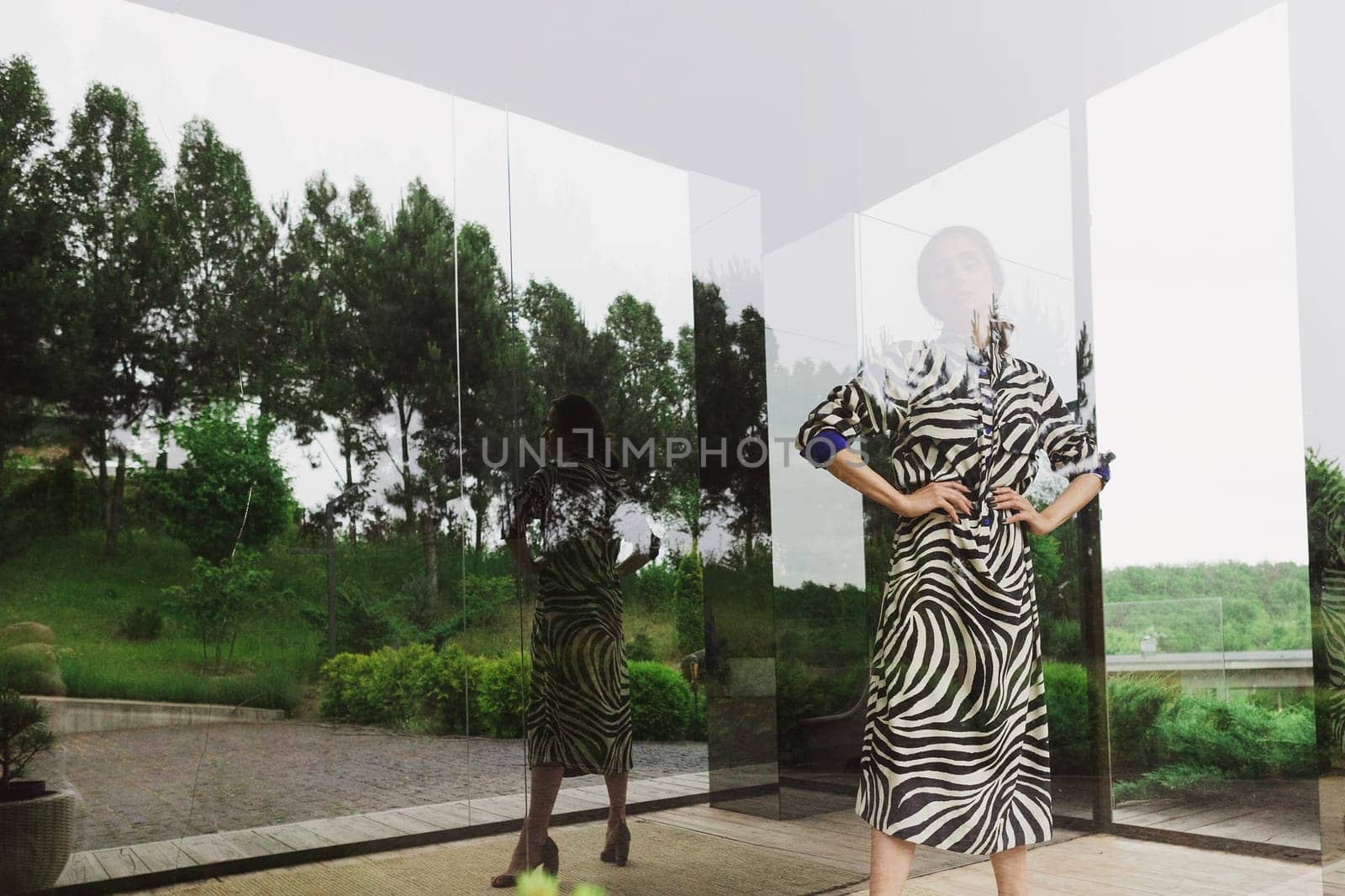 High fashion photo of a beautiful elegant young woman in a pretty zebra print dress posing outdoor. Slim figure by sarymsakov
