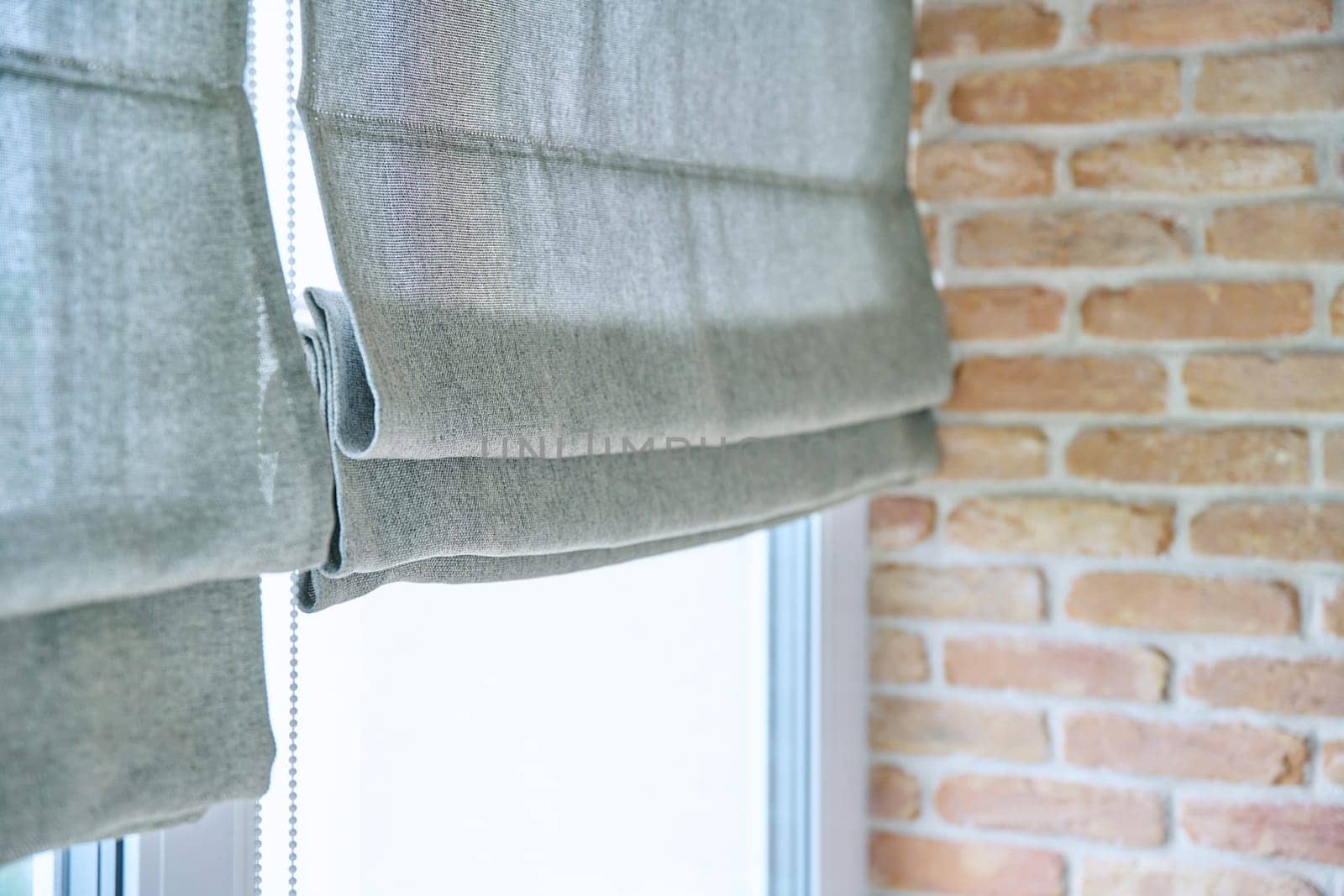 Close-up of roman blinds with gray linen fabric by VH-studio