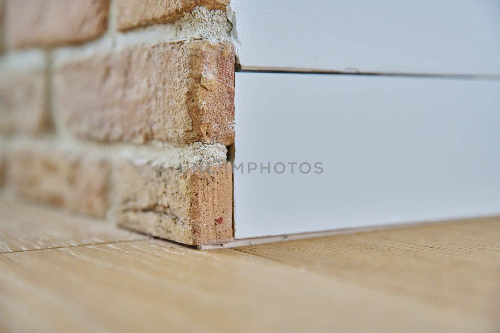 Close-up of corner, floor plinth inside wall, edge of brick wall by VH-studio