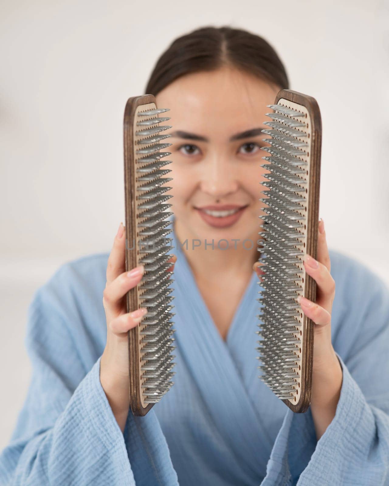 Asian woman holding sadhu boards on face background