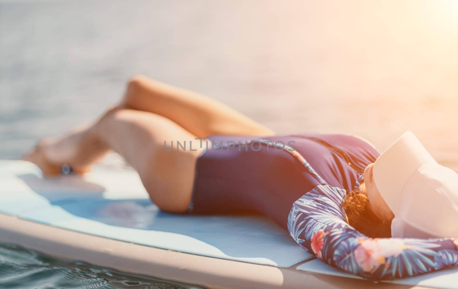 Woman sup yoga. Middle age sporty woman practising yoga pilates on paddle sup surfboard. Female stretching doing workout on sea water. Modern individual hipster outdoor summer sport activity