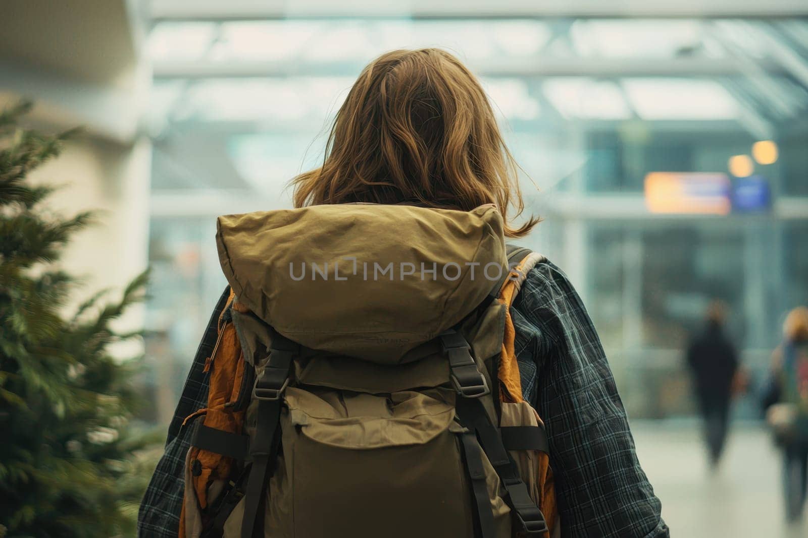 A young backpacker gazes at the flight board in an airport terminal, capturing the essence of travel and adventure in an exciting environment.