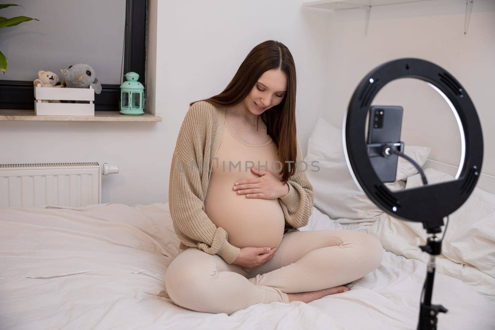 A serene and peaceful pregnant woman gently caressing her belly, enveloped by cozy and inviting decor