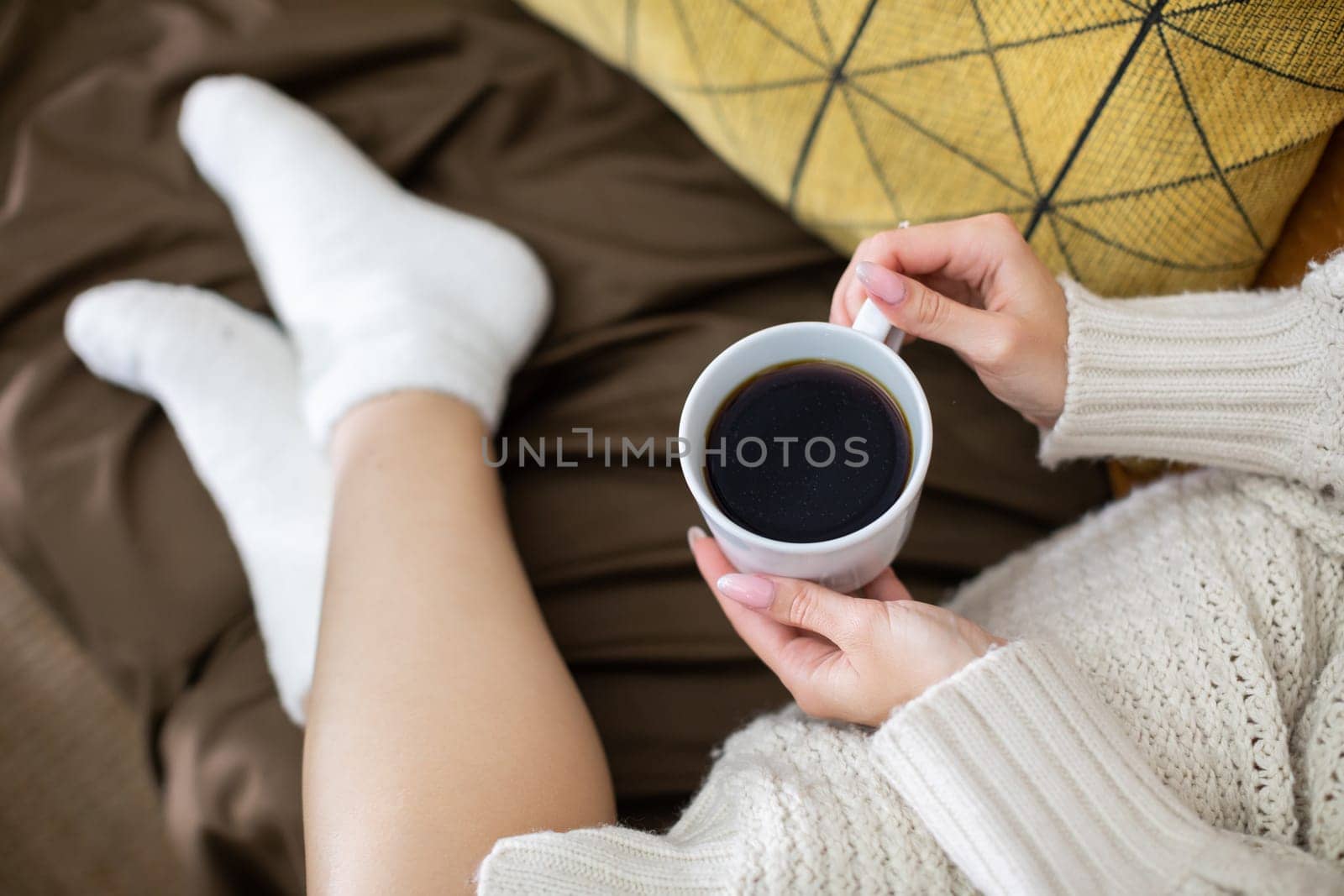 A truly serene moment savoring a delicious cup of coffee while cozy in soft clothing and warm, fuzzy socks