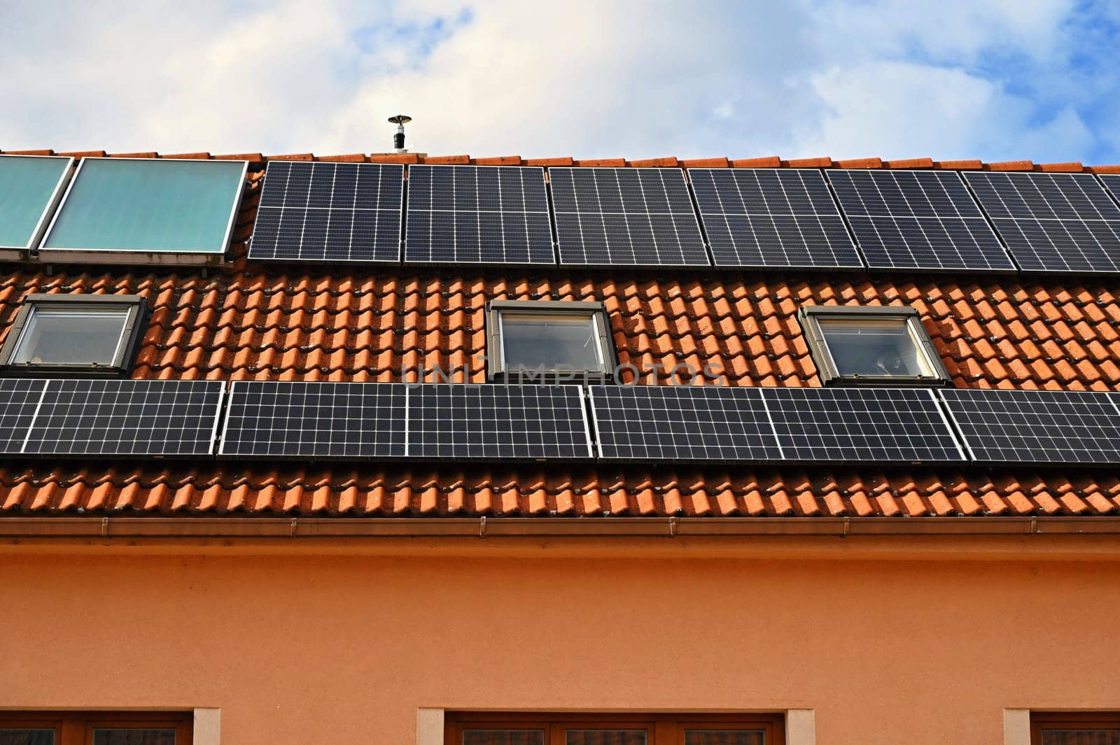 Family house with solar panels on the roof. Home photovoltaic power plant. Concept for industry and green cheaper electricity from renewable sources.