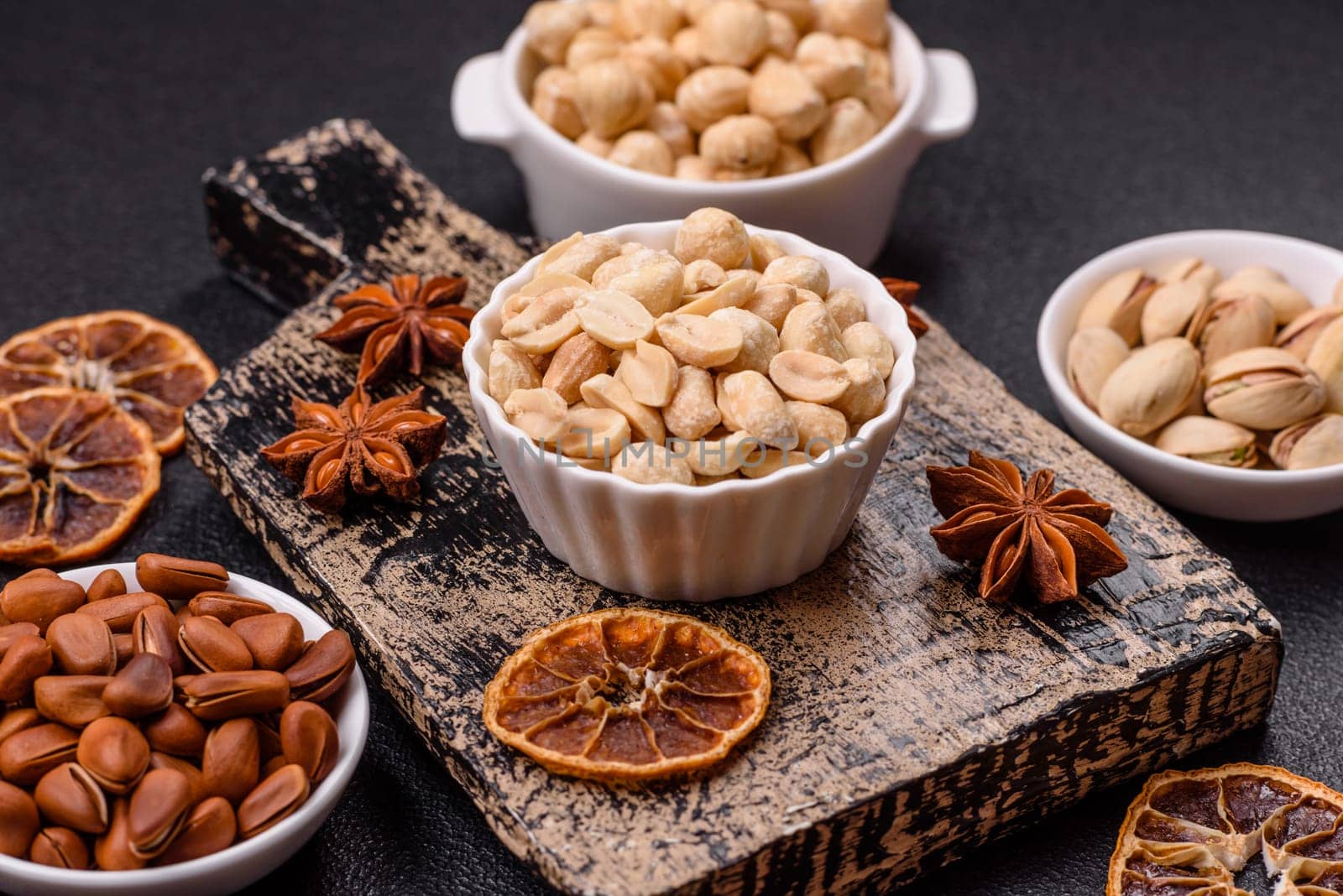 Delicious nutritious peanut in ceramic bowl on dark concrete background