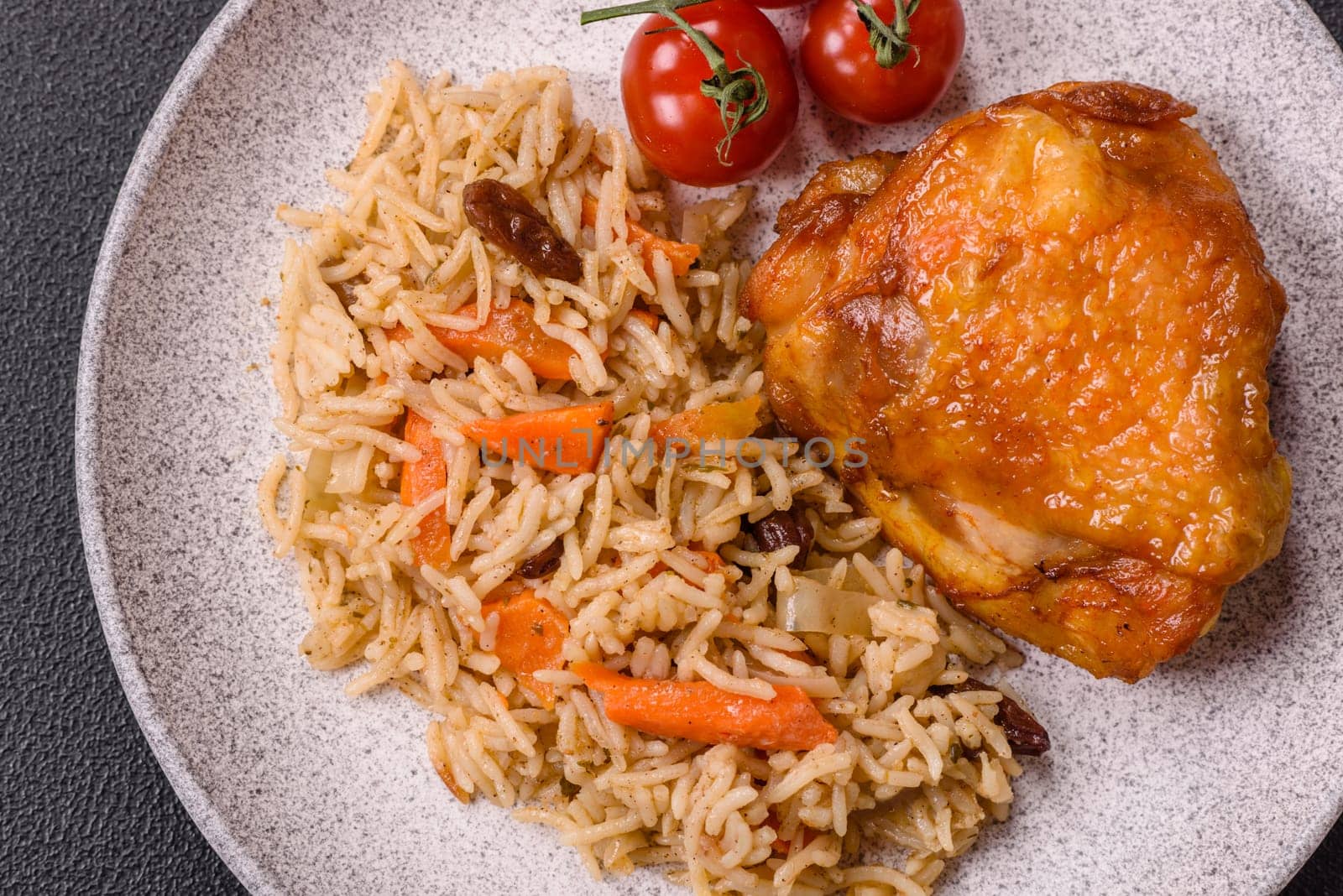 Delicious fresh pilaf with rice, carrots, meat, onions, spices and berries on a ceramic plate on a dark concrete background
