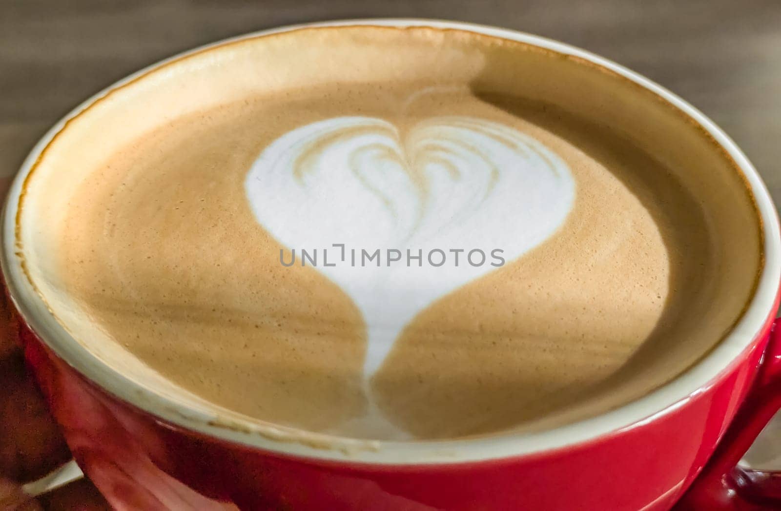 Hot cappuccino coffee with a heart pattern on the foam in a ceramic cup