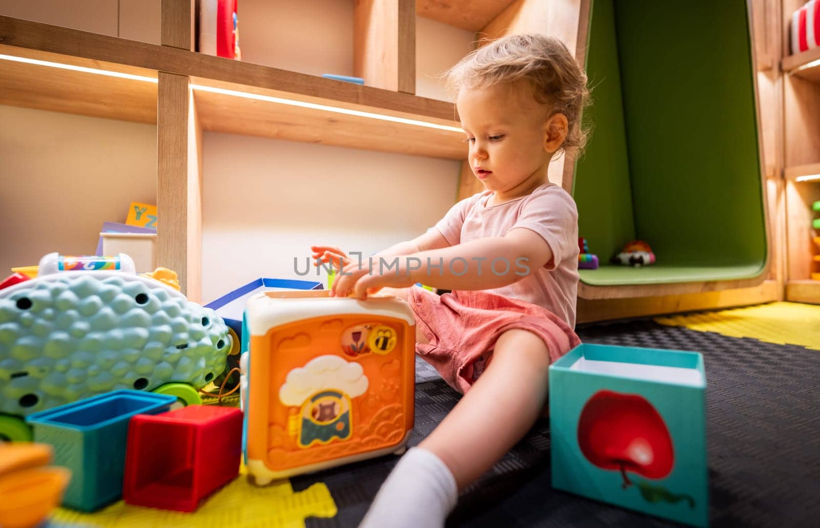 Toddler exploring colorful blocks and toys in a creative indoor playroom
