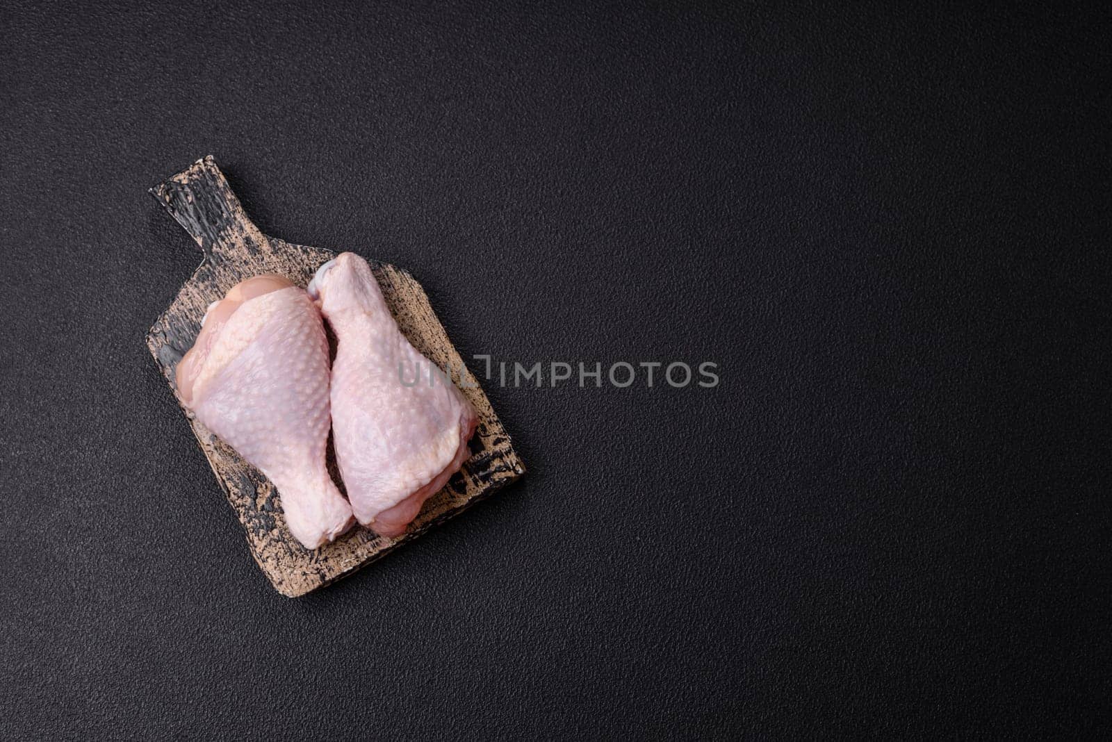 Raw chicken legs with salt, spices and herbs prepared for grilling