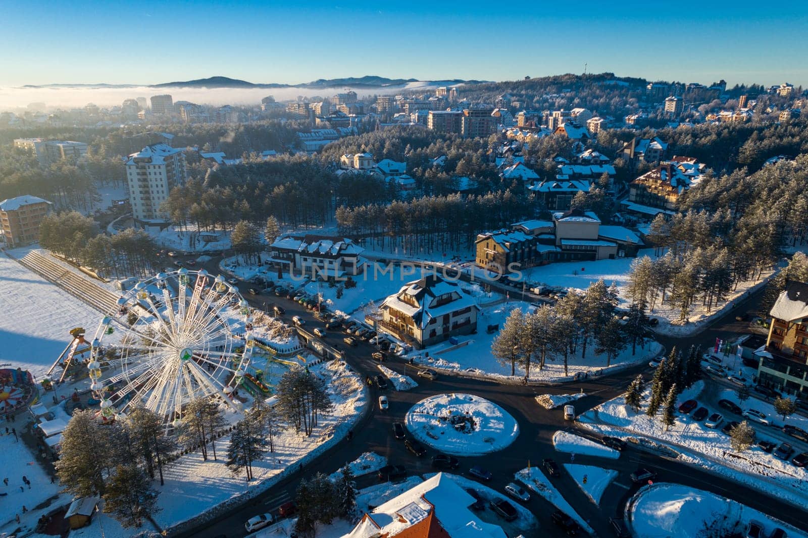 Panoramic aerial view of Zlatibor amusement park and low cloud over Zlatibor Mountain at winter sunset, Cajetina, Serbia.
