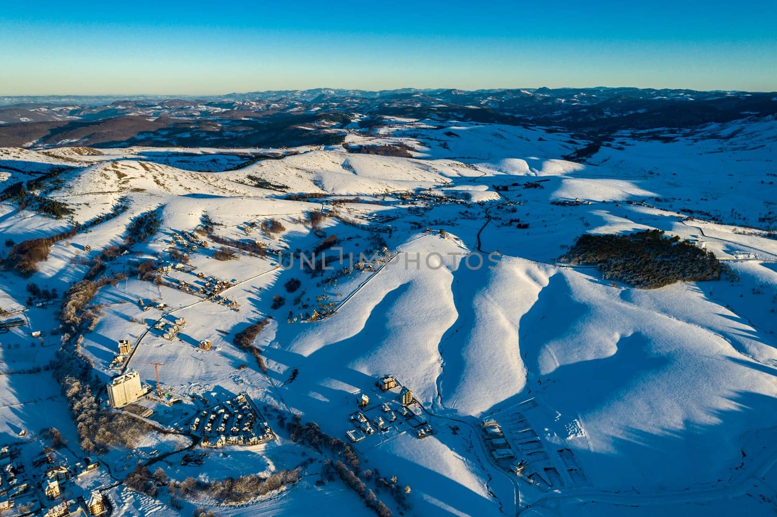 Panoramic aerial view of Zlatibor town and low cloud over Zlatibor Mountain at winter sunset, Cajetina, Serbia.