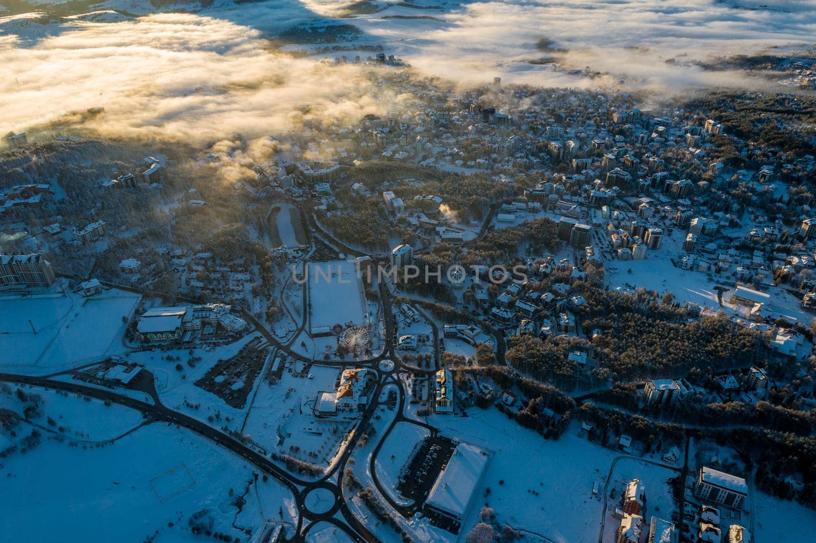 Panoramic aerial view of Zlatibor town and low cloud over Zlatibor Mountain at winter sunset, Cajetina, Serbia.