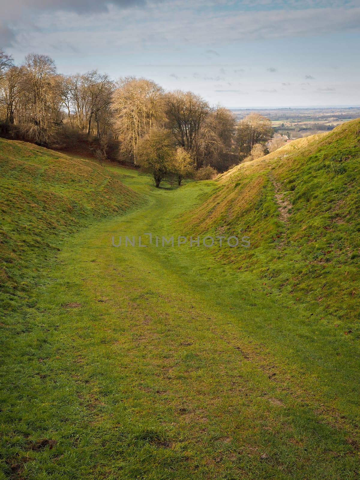 Walking down Kingstone Coombes, a dry valley formed during the Ice Age, from the Ridgeway, with the village of Ashbury visible in the distance, Oxfordshire, UK