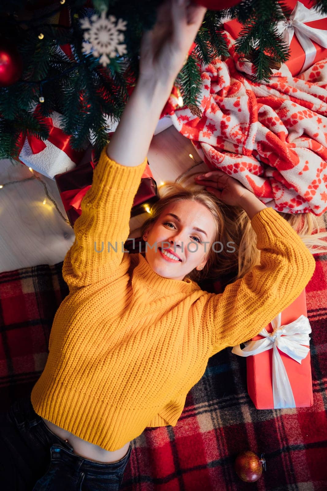 blonde lying by the Christmas tree on New Year's Eve Christmas