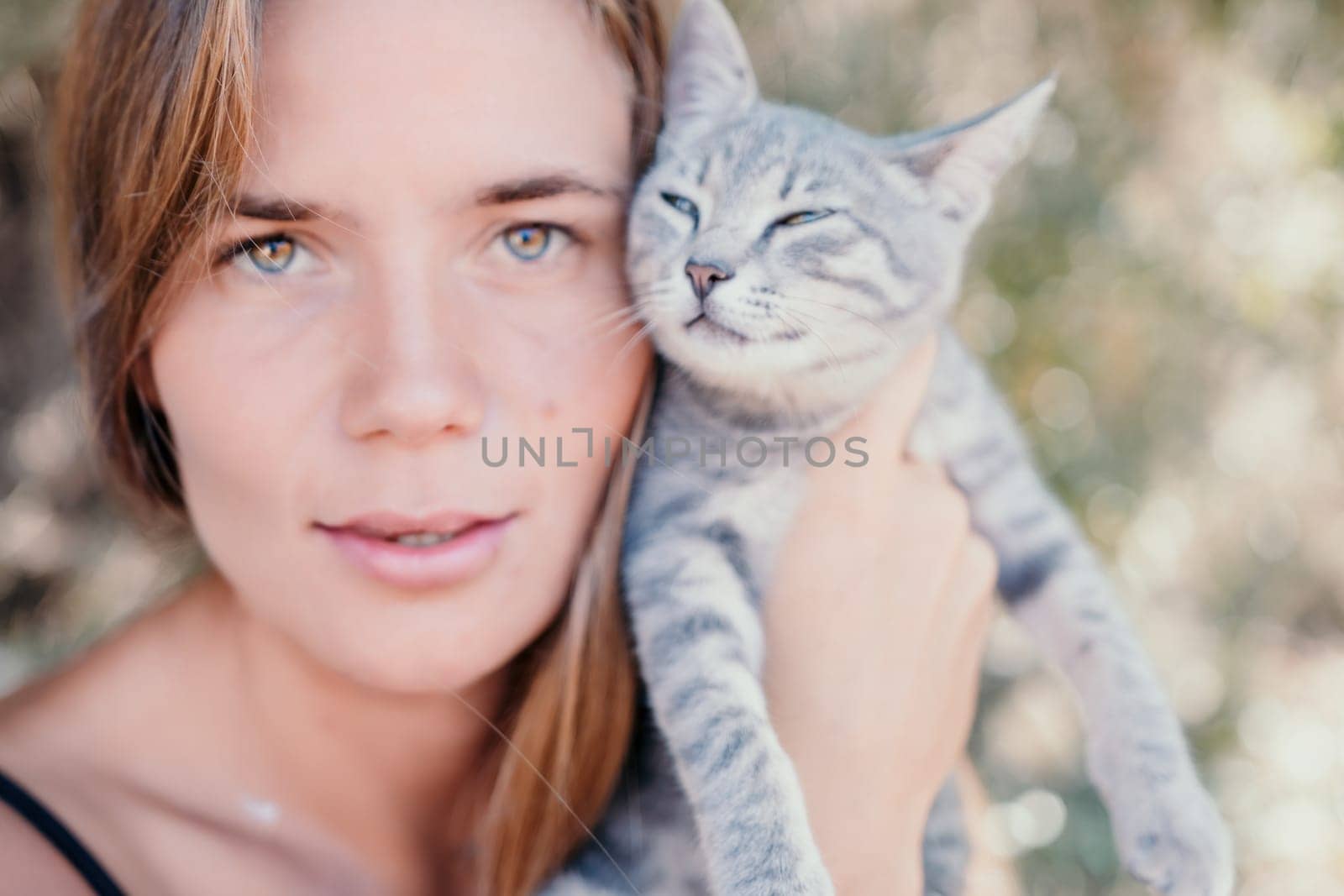 Woman summer travel cat. A woman on vacation with her pet cat enjoying a photo session on the beach. Travel and holiday concept. by panophotograph