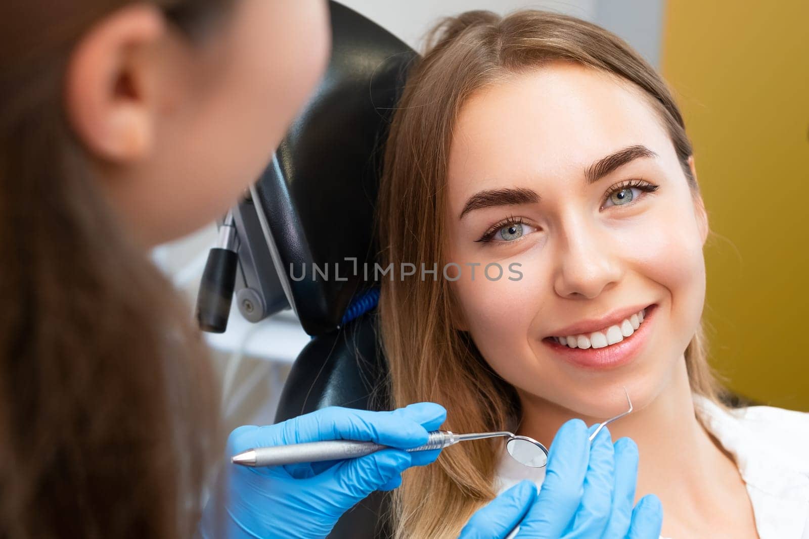 Brown-haired young woman preparing for dental procedure by vladimka